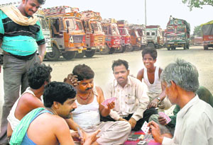 Truckers play cards following suspension of work due to a strike in Chandigarh on Wednesday.