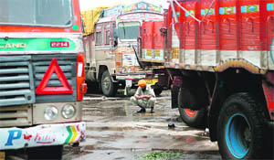 A truck driver rests between vehicles at a terminal on the outskirts of Mumbai on Wednesday.