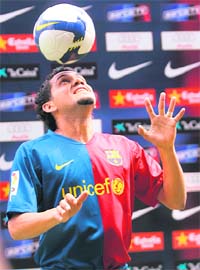 Barcelona's new signing Brasilian Dani Alves plays with a ball at the Nou Camp stadium in Barcelona