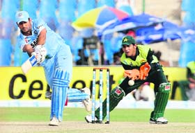 Pakistan wicket-keeper Sarfaraz Ahmed (R) watches as Mahendra Singh Dhoni plays a stroke during the Super League Asia Cup match between India and Pakistan at the National Stadium in Karachi