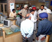 Senior Superintendent of Police Naunihal Singh talking to staff members of the bank in Bathinda on Thursday. 