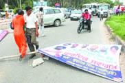 Protesters throw a hoarding on the GT Road to block traffic near Rama Mandi Chowk during the bandh in Jalandhar