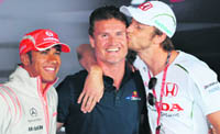 Hondas British driver Jenson Button (R) kisses Red Bulls Scottish driver David Coulthard (C) as McLaren Mercedes British driver Lewis Hamilton smiles as they arrive for a press conference at the Silverstone racetrack in England on Thursday, three days ahead of the Formula One British Grand Prix. Coulthard announced his retirement at the end of the season.