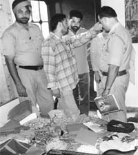 Policemen look for clues at the burgled house in Baltana on Friday.