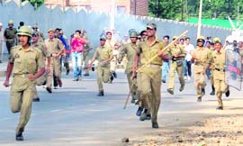 Cops rush towards protesters at Dargah Hazratbal in Srinagar on Friday.