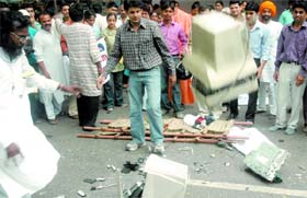 Activists of the Shaktipunj Foundation, an NGO, break computers, printers and other electronic items during the protest on the occasion of Radiation Safety Day at Jantar Mantar in New Delhi