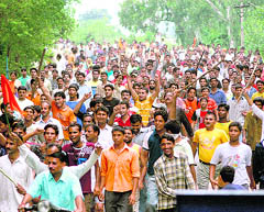 Angry protesters pelt stones at the police as they demonstrate against the revocation of the land transfer order in Jammu on Saturday. 