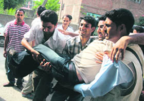Mediapersons carry an injured cameraman of a news channel allegedly beaten up by the CRPF and the police during a protest outside a shrine where fire broke out at Soura in Srinagar on Saturday. 