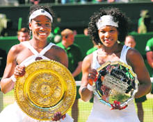 Venus Williams (L) poses with her trophy after beating her sister Serena during the final of the 2008 Wimbledon championships at The All England Tennis Club in southwest London, on Saturday. Venus won 7-5, 6-4.