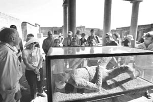 Visitors watch a mummy in Pompeli, which was destroyed in 79 AD by the eruption of Mount Vesuvius in this file photo taken on October 13, 2007.