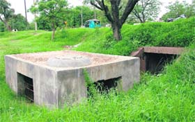 On the road separating Sectors 2 and 11, an open drain made of brick and mortar is blocked with garbage