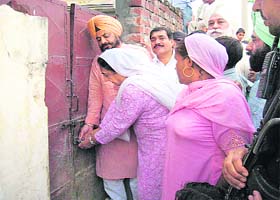 PPCC president Rajinder Kaur Bhattal opens the lock of the door of a house belonging to one of the Dalit families that had reportedly gone missing a few days ago due to fear of local MLA, at Fatehgarh Sahib