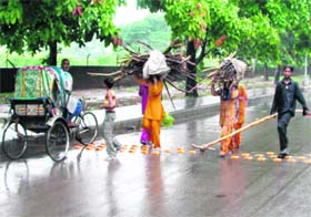 A rickshaw puller, two maidens carrying logs of wood and their young assistant grapple with rain in Chandigarh