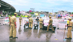 Policemen frisk people, who defied curfew, in Jammu on Sunday. 