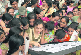 Students look up their names in the merit lists displayed by colleges in Ludhiana on Monday. 