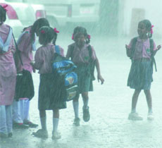 Children enjoy the rain after school hours in New Delhi on Tuesday.