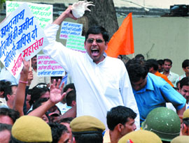 A member of the Dharmyatra Mahasangh holds a conch during a protest against the decision of the Jammu and Kashmir government over the Amarnath Shrine Board, in New Delhi on Tuesday.