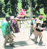 Four Kashmiri Muslims carry an elderly pilgrim on the way to Amarnath shrine, 115 km south-east of Srinagar