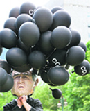 An activist dressed up as US President George W. Bush holds balloons symbolising his countrys carbon emissions at an anti-G8 event in Sapporo