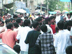 People gather on the spot where a gang war took place in the Seelampur area in New Delhi on Tuesday night. 