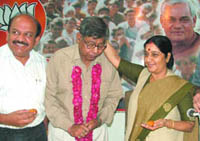 Retired additional district judge of Patiala House Court Rajesh Kumar takes blessings of BJP leader Sushma Swaraj after joining the party in New Delhi on Wednesday. Also seen in the picture is Delhi BJP president Harsh Vardhan.