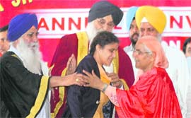 Monika, a visually impaired student of MTS College, receives the roll of honour for music from Parkash Singh Badal during the annual convocation of the college in Ludhiana on Thursday. 
