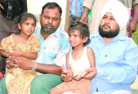 Shocked children, who escaped possible electrocution after a LT power line snapped, with their family members in Ludhiana on Wednesday evening.Photo: Inderjeet Verma