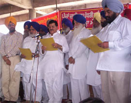 Transport minister Master Mohan Lal administering oath of office to newly elected panches in Moga on Friday. 