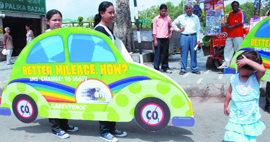 Greenpeace activists hold cut-outs of cars during a fuel efficiency awareness campaign at Connaught Place in New Delhi on Friday. The Greenpeace has launched a