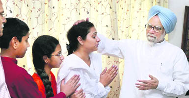 Prime Minister Manmohan Singh consoles IFS officer V V Raos widow V Malathi Rao and his children at their residence in New Delhi on Friday.