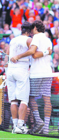 Roger Federer (R) congratulates Rafael Nadal who won the Wimbledon men’s final this year