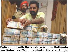 Policemen with the cash seized in Bathinda on Saturday. Tribune photo: Malkiat Singh