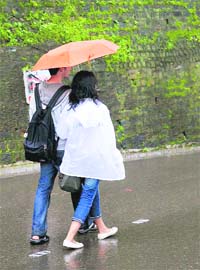 A young couple enjoys monsoon showers on The Mall in Shimla