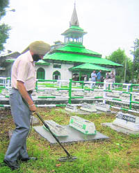 Security personnel inspect the Mazar-e-Shohda (martyrs graveyard) in Srinagar on Saturday. 