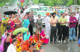 Members of the Computer Teachers Union block traffic at Bharat Nagar Chowk during a protest in Ludhiana on Saturday.