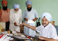 SDM Bathinda KPS Mahi distributing cheques as compensation for the acquired land, which would be used for constructing ring road, on Sunday.