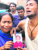 Parents of 11-year-old Arjun with his photo in Mohali on Monday.