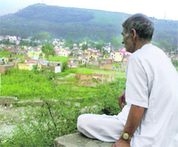A old man looks at the new town area in Rajouri.