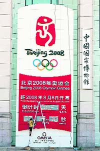 A Chinese worker spruces up the countdown clock for the 2008 Beijing Olympic Games on Tiananmen Square in Beijing