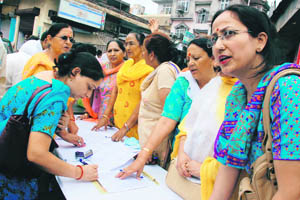 BJP activists at a signature campaign against the revocation of Amarnath land transfer, in Jammu on Monday.