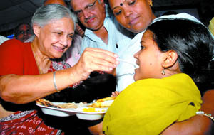 Delhi Chief Minister Sheila Dikshit offers food to a child at the inauguration of an Aap Ki Rasoi centre at R-Block, Mangolpuri, New Delhi.