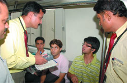 Officials of the DMRC flying squad check the tokens of the passengers inside a running train in New Delhi