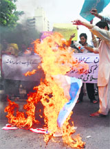 Activists of Islami Jammiat Talaba burn US and Israeli flags at a protest rally against the US air strikes in Pakistani tribal areas, in Karachi