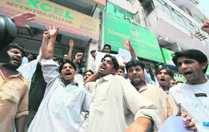 Angry Pakistani investors shout slogans outside the Islamabad Stock Exchange (ISE) in Islamabad on Thursday at a protest against the continued decline in Pakistani share prices.