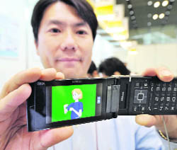 A Hitachi researcher displays the prototype model of a mobile phone which displays the 3D animation for sign language in Tokyo on Thursday. The users can change viewing angles and enlarge animated images with the prototype. 