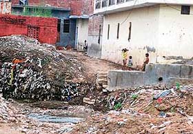 Children playing near heaps of garbage near an open drain in Mauli Jagran in Mani Majra