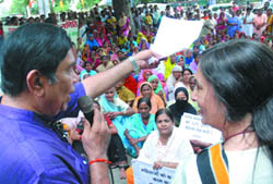 Labour minister Oscar Fernandes interacts with activists of the All-India Democratic Womens Association while Left leader Brinda Karat looks on during their protest march outside the office of the labour ministry in New Delhi on Thursday. 