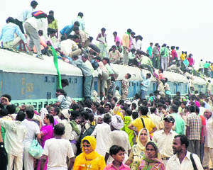 Devotees try to board a crowded train to take part in the Guru Purnima in Goverdhan, near Mathura, on Thursday.