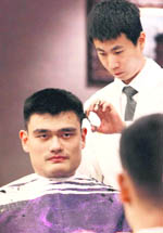Chinas towering basketball superstar Yao Ming gets a haircut after arriving with the national team for the Stankovic Cup in Hangzhou on Wednesday. 