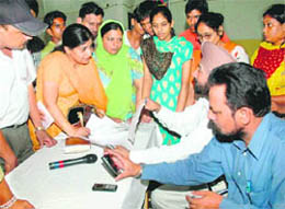 Parents inquire about the admission schedule from education officials at GMSSS-10 in Chandigarh on Friday.
